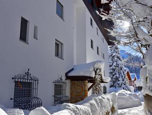 a snow covered building with a fireplace in front of it at Monami Apartments Klosters, Apt. Casa Selva Nr 10 in Klosters