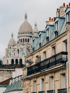 une vue sur un bâtiment avec une cathédrale en arrière-plan dans l'établissement Hotel Luxia, à Paris