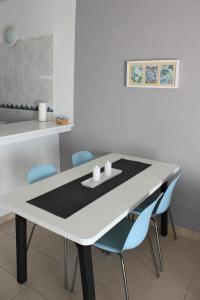 a white dining room table with blue chairs at Apartamento II Callao Salvaje in Callao Salvaje