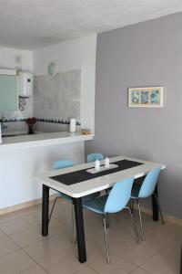 a dining room with a table and blue chairs at Apartamento II Callao Salvaje in Callao Salvaje