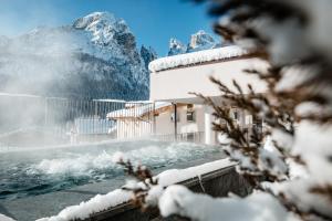 a building in front of a snow covered mountain at Hotel Gran Ciasa in Colfosco