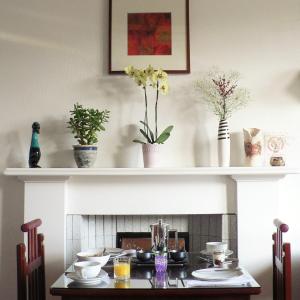 a dining room with a table and a fireplace at Straven Guesthouse in Edinburgh