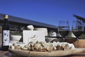 a plate of food and two wine glasses on a table at Agriturismo Fattoria delle Milizie in Scicli