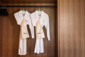 three white shirts and ties hanging on a wall at ION Adventure Hotel, Nesjavellir, a Member of Design Hotels in Nesjavellir
