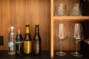 three bottles of beer and two wine glasses on a shelf at ION Adventure Hotel, Nesjavellir, a Member of Design Hotels in Nesjavellir