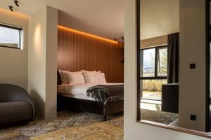 a bedroom with a bed with a mirror and a window at ION Adventure Hotel in Nesjavellir