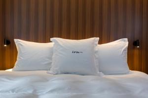 a bed with white pillows with the word liar written on them at ION Adventure Hotel, Nesjavellir, a Member of Design Hotels in Nesjavellir