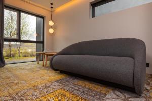 a couch sitting in a room with a window at ION Adventure Hotel, Nesjavellir, a Member of Design Hotels in Nesjavellir