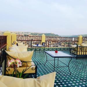 patio ze stołami i krzesłami na dachu w obiekcie Riad Tafilalet w Fezie