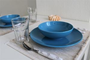 a table with two blue bowls and a glass at Dali Rooms in Chania