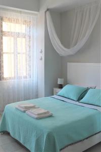 a bedroom with a green bed with towels on it at Dali Rooms in Chania Town