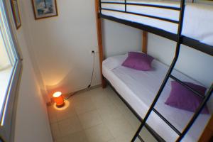 a small room with a bunk bed and a candle at Agi Torre Quimeta Apartments in Roses