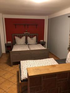 Petrovice的住宿－Penzion RETRO，一间卧室设有两张床和红色的墙壁