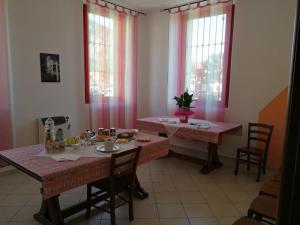 a dining room with two tables and two windows at OSTELLO DI SAN GERMANO in Borgofranco dʼIvrea