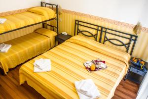 2 camas en una habitación con un plato de comida en Hotel Consul - Family Hotel, en Riccione