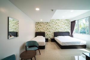 Un dormitorio con dos camas y una silla y una mesa. en Crystal Garden Hotel - Tasik Selatan, en Kuala Lumpur 22 fotos más