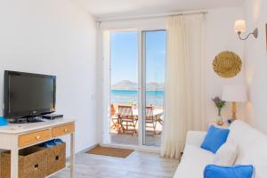 a living room with a television and a view of the ocean at Villa LA CALMA Alcudia in Alcudia