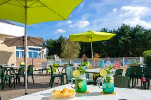 a table with drinks on it with tables and umbrellas at VTF Le Sénéquet in Blainville-sur-Mer