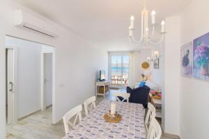 a dining room and living room with a table and chairs at Villa LA CALMA Alcudia in Alcudia