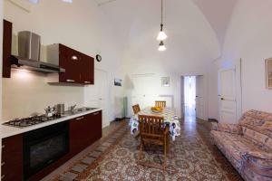 a kitchen and living room with a table and a couch at Casa vacanza La Stradella in Ostuni