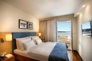 a hotel room with a bed and a large window at Valamar Riviera Hotel & Residence in Poreč +45 photos