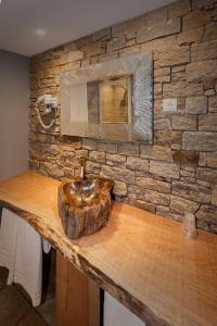 a stone wall with a sink on a wooden counter at A Fontana in Zonza