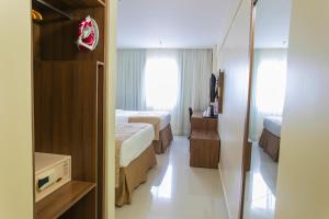 ein Hotelzimmer mit 2 Betten und einem Spiegel in der Unterkunft Holiday Inn Express Belem Ananindeua, an IHG Hotel in Belém