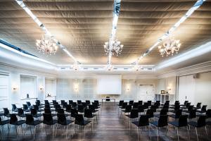 a large room with chairs and a podium in it at First Hotel Grand in Odense