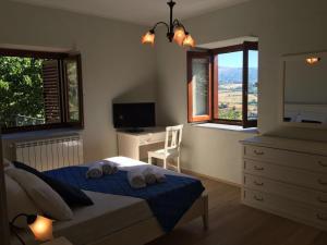 een slaapkamer met een bed, een dressoir en ramen bij Green Deluxe Apartment “La locanda del Borgo” in San Donato di Ninea