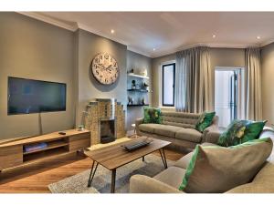 a living room with a couch and a tv at Greenpoint Apartments in Cape Town