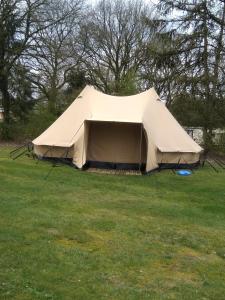 a large tan tent in a field of grass at Tent-Ok Meppen in Meppen