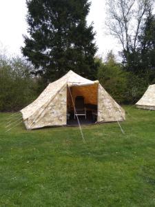 Meppen的住宿－Tent-Ok Meppen，田野中间带椅子的帐篷