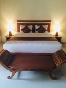 a large bed with two lamps on either side of it at The Tinsi in Nusa Penida