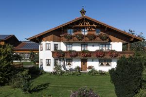 Berghof Walser في Obersöchering: بيت ابيض كبير عليه علب ورد