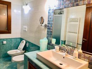 a bathroom with a sink and a toilet and a mirror at Villa Edo in Cala Liberotto +68 photos