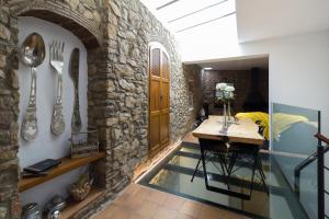 a dining room with a table and a stone wall at Can Martí Sistachrentals in Torroella de Montgrí