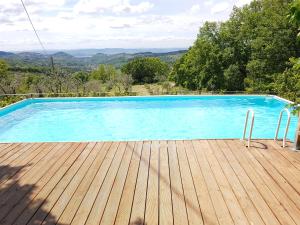 a blue swimming pool with a wooden deck at Agriturismo Podere il Palagio in Fiesole