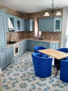 een keuken met blauwe kasten en een tafel en blauwe stoelen bij La casa Azzurra in Ischia