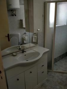 La salle de bains est pourvue d'un lavabo blanc et d'une douche. dans l'établissement La casa Azzurra, à Ischia