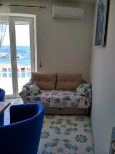 un soggiorno con divano e vista sull'oceano di La casa Azzurra a Ischia
