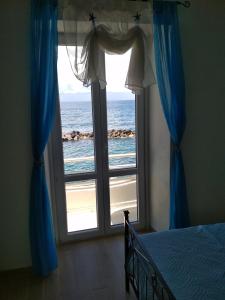 una camera da letto con finestra affacciata sull'oceano di La casa Azzurra a Ischia