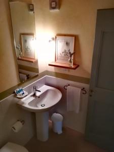 a bathroom with a sink and a mirror and a toilet at Agriturismo Pian Del Tevere in Torgiano
