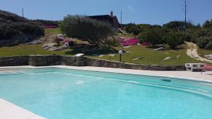 a large swimming pool in a yard with a garden at La Chintana in Palmadula