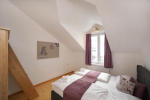 sypialnia z łóżkiem i oknem w obiekcie City Apartments Mozart w mieście Zell am See