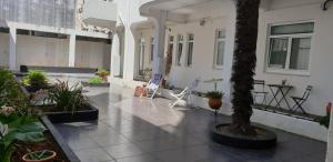 une cour avec des plantes et des chaises dans un bâtiment dans l'établissement Cagaréus, à Aveiro