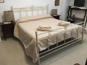 ein Bett mit einer weißen Tagesdecke und einer Handtasche darauf in der Unterkunft B&B Domus Gaetani in Syrakus