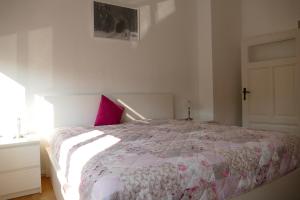 ein Schlafzimmer mit einem Bett mit einem rosa Kissen in der Unterkunft Spatzennest in Wernigerode