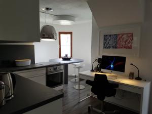 a kitchen with a desk with a computer on it at Little Castle near Airport and Messe in Steinenbronn