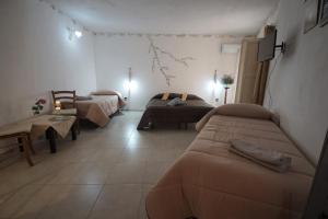 ein Zimmer mit 2 Betten und ein Wohnzimmer mit einem Sofa in der Unterkunft Alfa Quadro in Agrigento