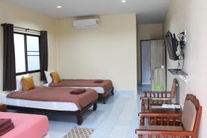um quarto com duas camas e uma televisão em Sirikul Mansion em Nai Yang Beach